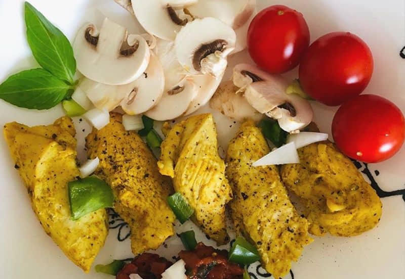 Ein Teller mit Essen mit Tomaten und Pilzen