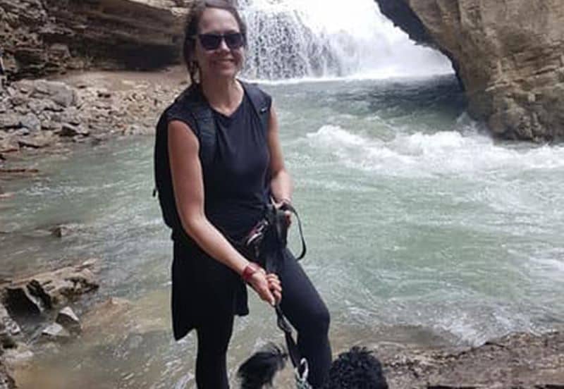 Victoria Burns avec un chien devant une cascade