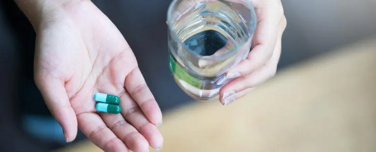 Image10 11Zon 4 A Hand Holding A Glass Of Water And Two Pills Of Magnesium