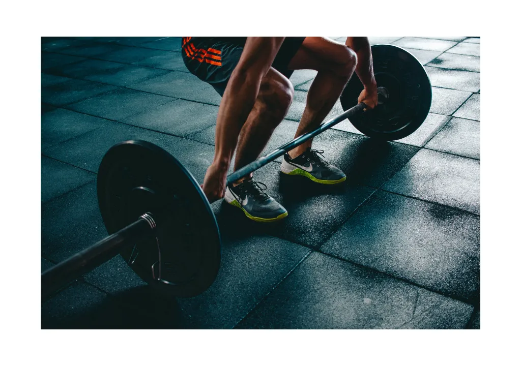 Un hombre levantando pesas en el suelo de un gimnasio