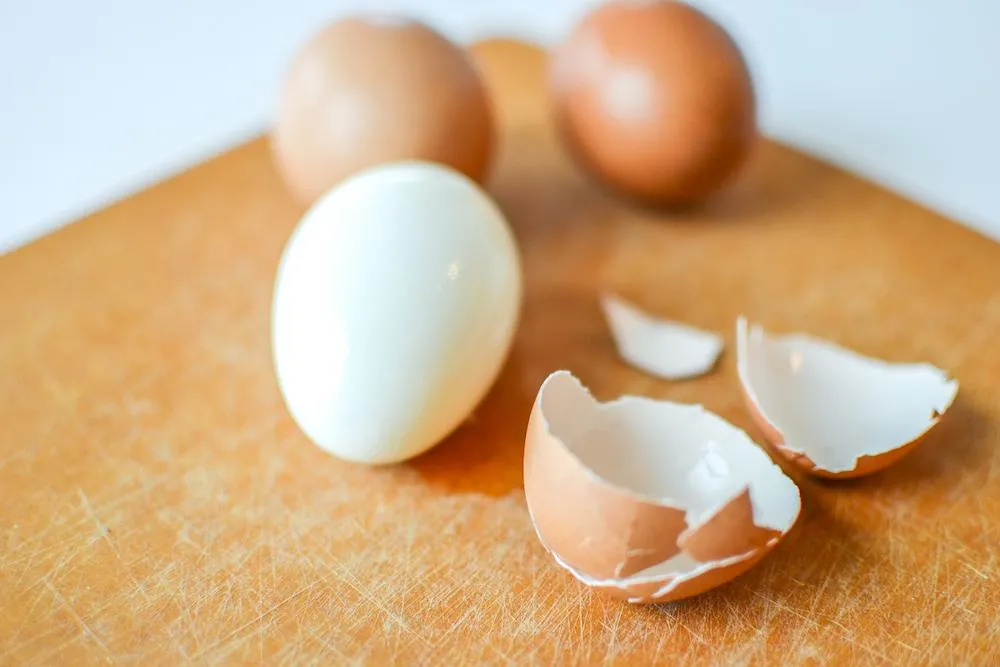 Image5 11Zon 21 A Hard Boiled Egg And A Broken Egg Shell On A Wooden Surface