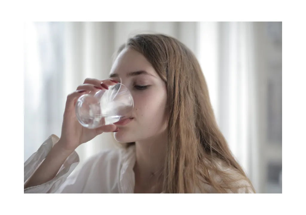 Una mujer bebiendo un vaso de agua
