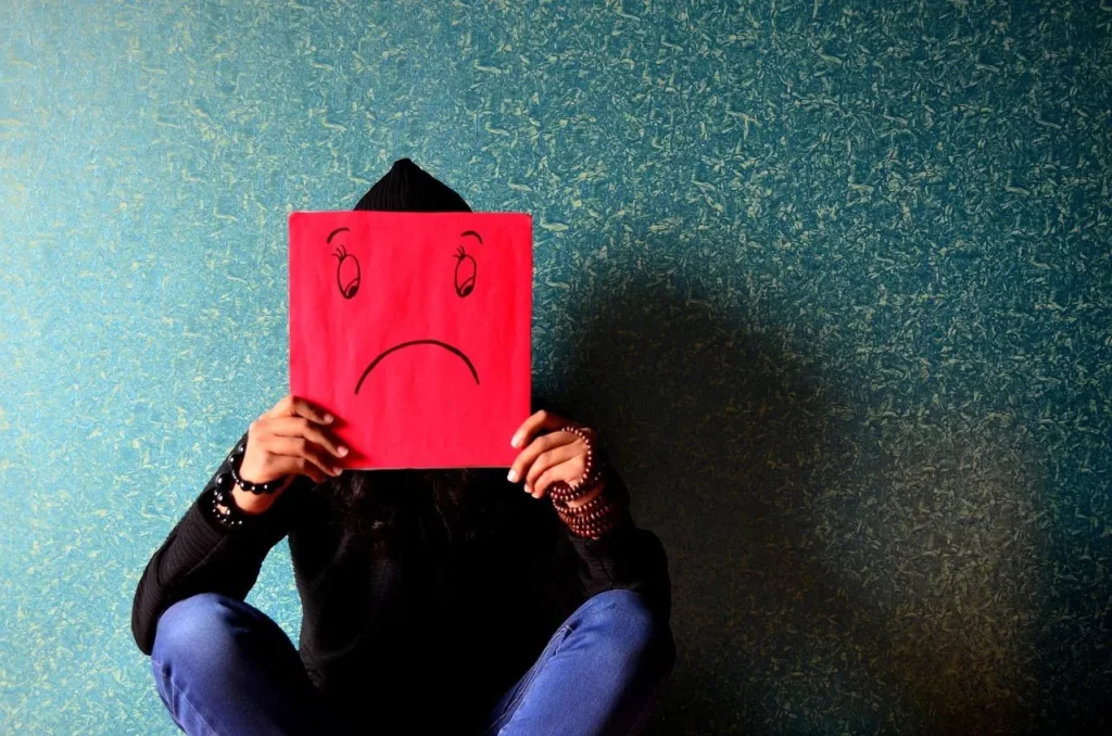 Image6 11Zon 5 A Person Holding A Red Sign With A Sad Face Drawn On It