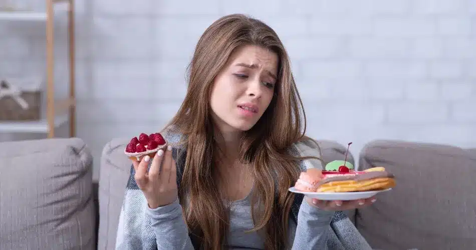 Stress And Emotional Eating A Woman Holding A Plate Of Dessert