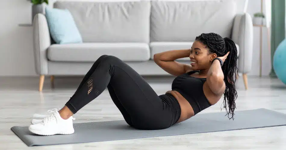 Short Daily Workouts Lower Blood Sugar Naturally Person Doing Abdominal Exercises On A Yoga Mat At Home, Highlighting Simple Daily Workouts That Help Lower Blood Sugar And Improve Insulin Sensitivity.